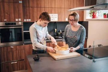 Dvě osoby, které společně vaří, představující komunitu podporující dospělé s autismem