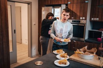 Dvě osoby v kuchyni v Novém domově, představující komunitu podporující dospělé s autismem.