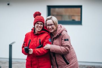 Skupina lidí s úsměvem, představující komunitu podporující dospělé s autismem.