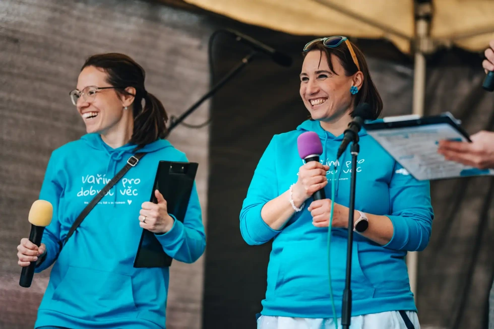 Dvě moderátorky v modrých tričkách s logem festivalu